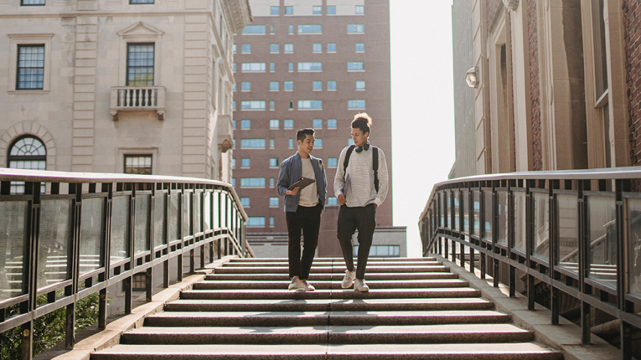 Two young men walking on stairs outside