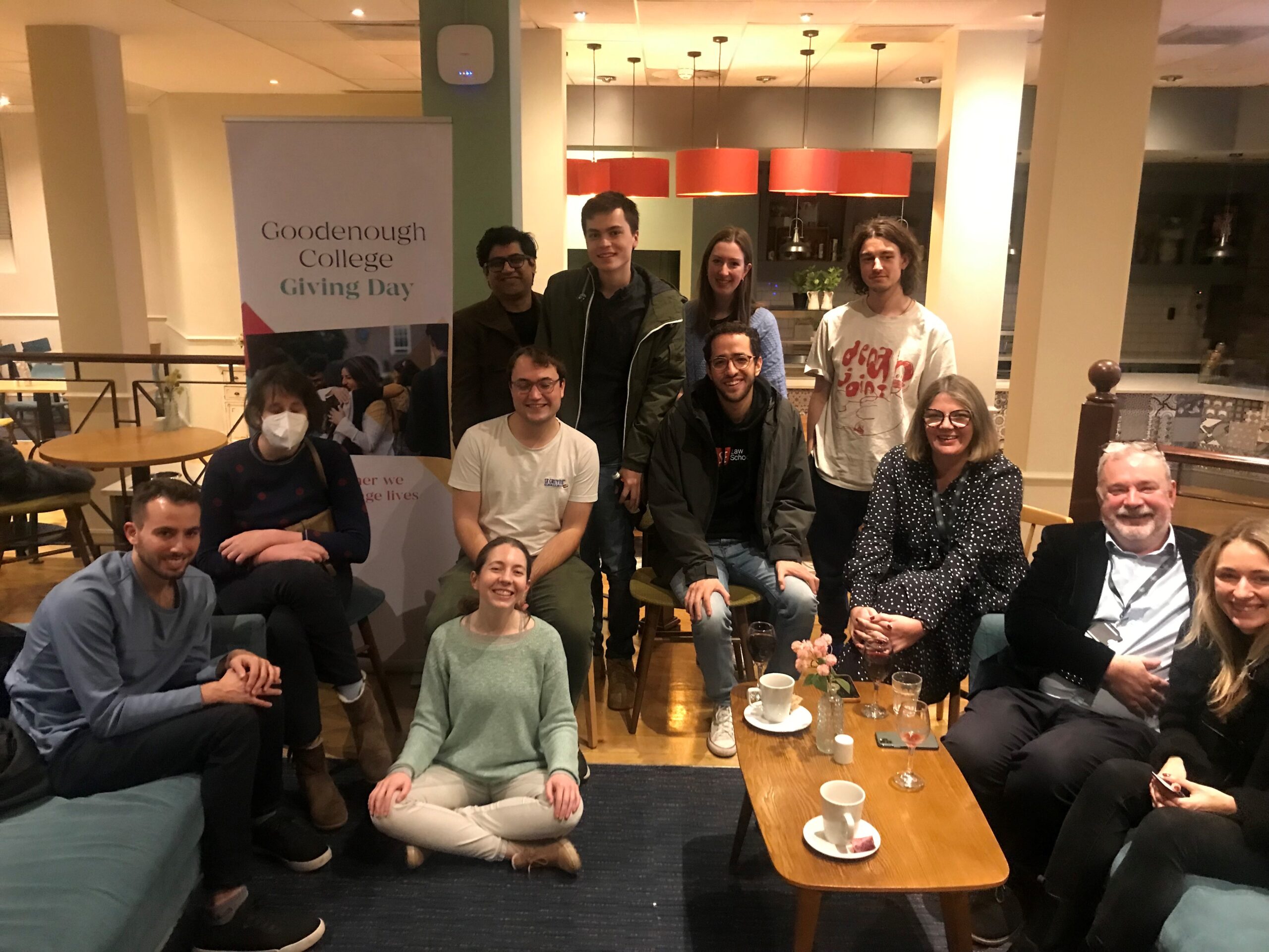 Goodenough College Members at Freddie's with Goodenough College Giving Day banner