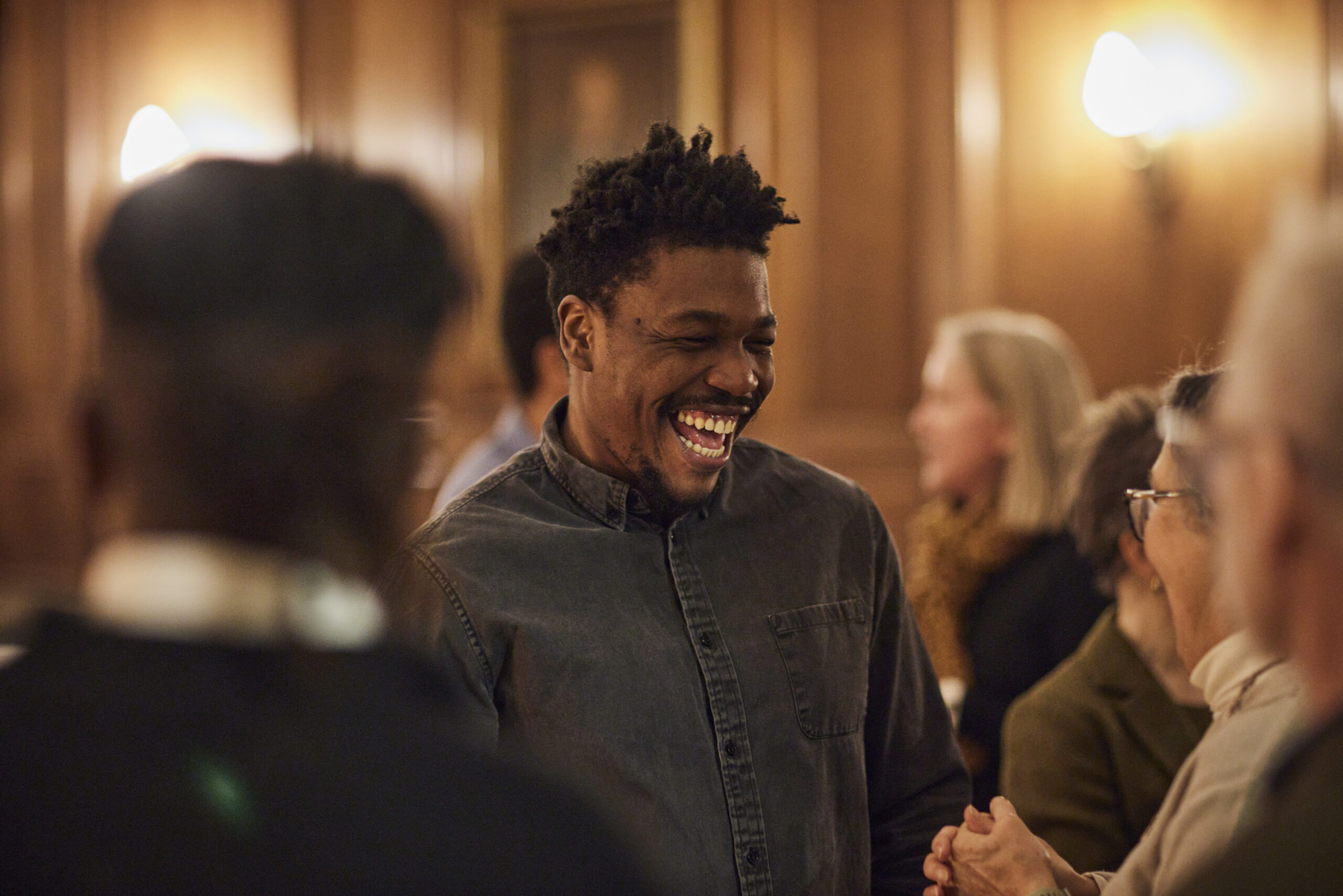 Person smiling at an indoor social event