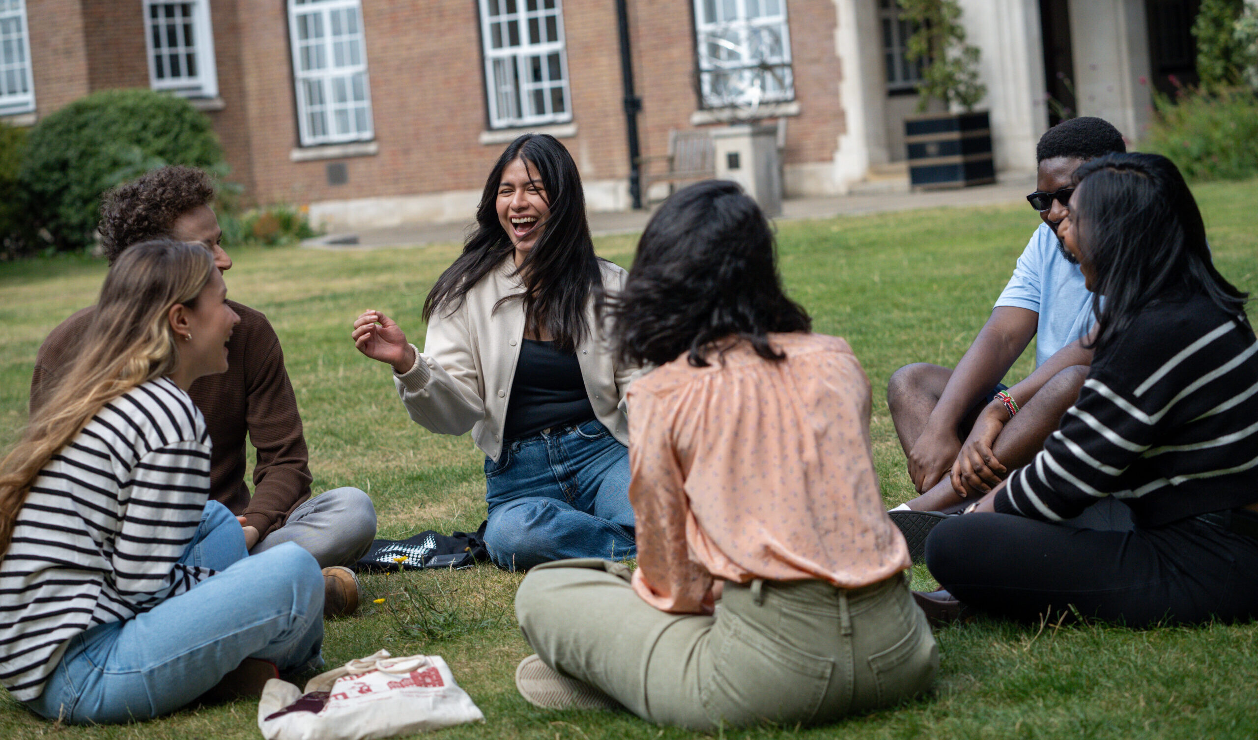 A group of Goodenough College Members sitting in a circle in London House quad